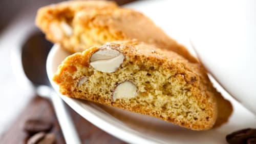 Biscotti alle mandorle affettati con mandorle intere su piatto bianco alla locanda B&B I Coppi, San Gimignano