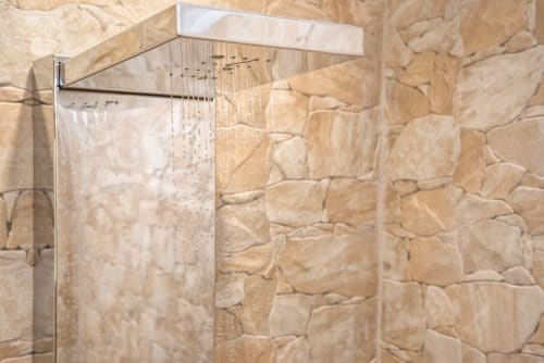 Modern rainfall shower head with stone-tiled walls at Villa Freedom boutique B&B in Kokkino Chorio, Crete