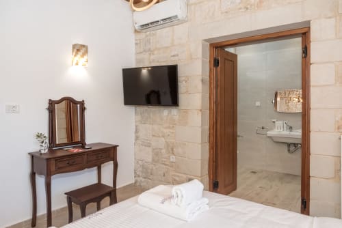 Villa Freedom bedroom in Kokkino Chorio, Crete with en-suite bathroom, wooden vanity, and flat-screen TV