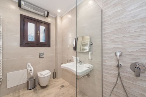 Modern bathroom at Villa Freedom Crete with walk-in shower, sink, toilet, and heated towel rail