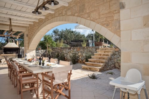 Villa Freedom outdoor dining area with stone archway, wooden chairs, and Cretan landscape in Kokkino Chorio
