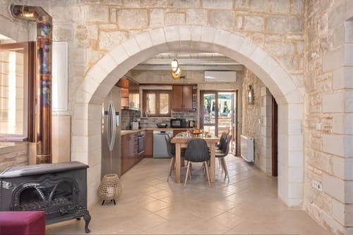 Villa Freedom kitchen and dining area in Crete with stone arches, wooden cabinets, and modern appliances