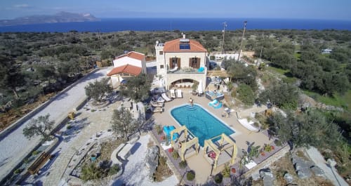 Aerial view of Villa Freedom guesthouse with pool and terrace overlooking Cretan sea and islands