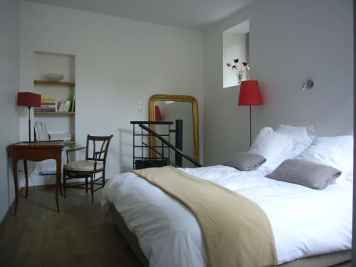 Bright double bedroom at Le Jardin De Beauvoir B&B in Lyon with white bedding, desk, red lamp, and classic furnishings