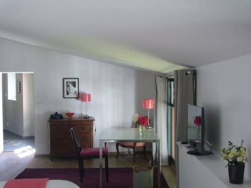 Modern junior suite at Le Jardin De Beauvoir, Lyon with dining table, wooden dresser, fresh flowers, and garden view curtains