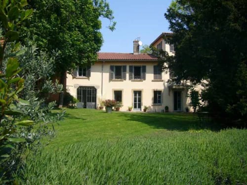 Le Jardin De Beauvoir B&B in Lyon features a cream-colored villa with manicured gardens and green lawn