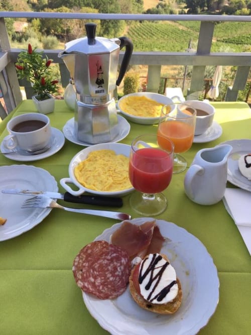 Colazione italiana a B&B I Coppi a San Gimignano: caffè, pasticcini, succo di frutta e vista sulla campagna toscana