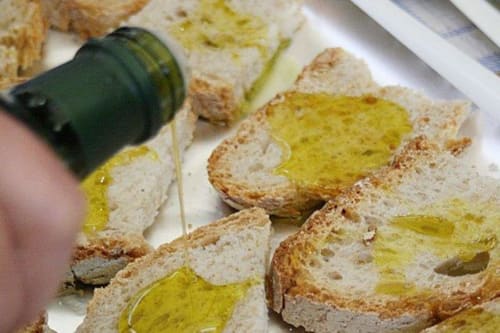 Olio d'oliva versato su pane tostato presso il B&B I Coppi a San Gimignano