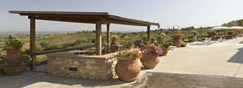 Terrazza toscana di B&B I Coppi a San Gimignano con pergolato, vasi in terracotta e vista sulla campagna