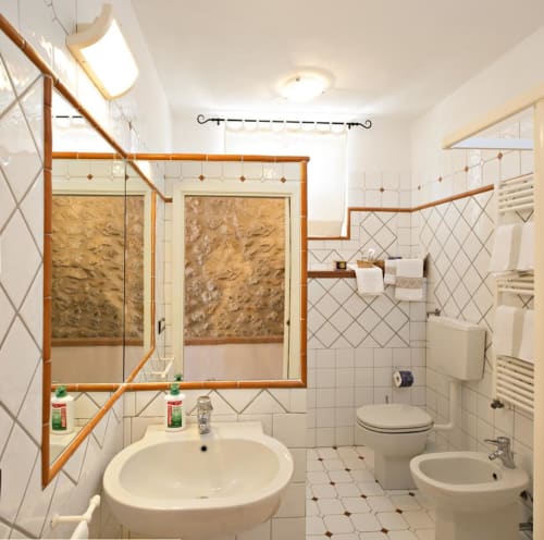 Bagno moderno con doccia walk-in, lavabo rotondo, WC e bidet presso B&B I Coppi a San Gimignano