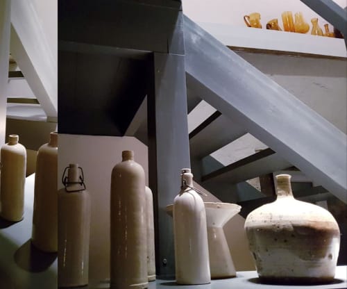 Keramische flessen en vazen tentoongesteld in Moulin Renaudiots, een Frans potterie-hotel in Autun met modern design