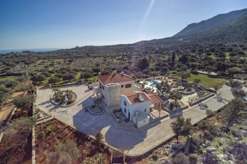 Villa Freedom B&B aerial view with white buildings, terracotta roof, pool, and olive groves in Kokkino Chorio, Crete