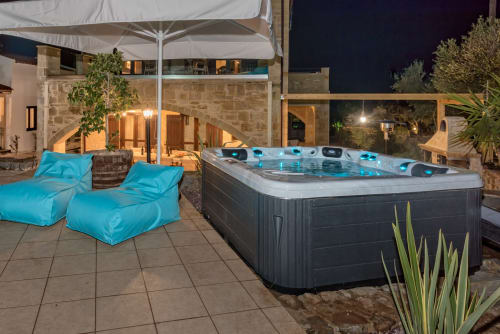 Villa Freedom hot tub and lounge area at night in Kokkino Chorio, Crete with blue bean bags
