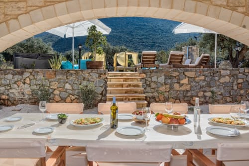 Villa Freedom dining terrace in Kokkino Chorio, Crete with sea views, set table, and stone architecture