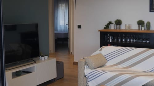 Modern bedroom at Ty Pals B&B in Pals with bed, TV, potted plants, and wooden floors