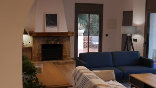 Ty Pals B&B living room with fireplace, dark blue sofa, wooden coffee table, and glass doors to terrace in Pals