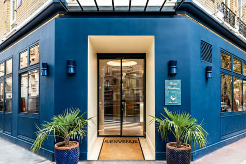 Hotel Residence Europe & Spa entrance in Clichy with blue facade, welcoming doors, and potted plants