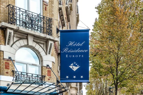 Hotel Residence Europe signage on Parisian building facade with ornate balconies and autumn trees