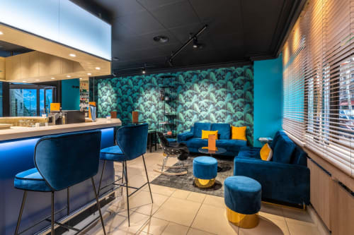 Modern hotel lounge at Hotel Residence Europe & Spa with blue velvet seating, tropical wallpaper, and contemporary design in