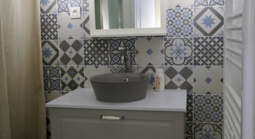 Vasque salle de bain moderne noire ronde avec carrelage bleu-gris patterné à La Maison Virginie
