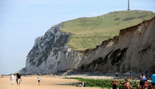 Les falaises de craie blanche dominent la plage de sable à Autingues, France, près du Au Petit Tambour D'Autingues