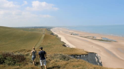 Randonneurs admirant les falaises côtières et la plage près d'Autingues, gîte en France
