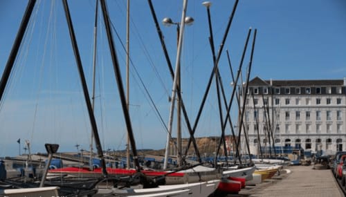 Voiliers amarrés au port avec bâtiment historique à Au Petit Tambour D'Autingues, France