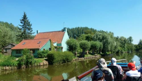 Au Petit Tambour D'Autingues, gîte à Autingues avec maison aux toits rouges au bord d'un canal tranquille et verdure luxuriante