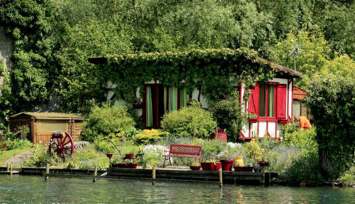 Au Petit Tambour D'Autingues : chaumière au bord de l'eau avec volets rouges, verdure luxuriante et jardin au fil de l'eau à Autingues, France