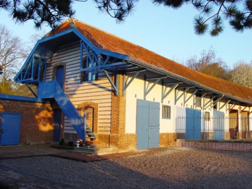 Au Petit Tambour D'Autingues, a charming brick barn-style BnB in Autingues, France, with blue timber framing and terracotta