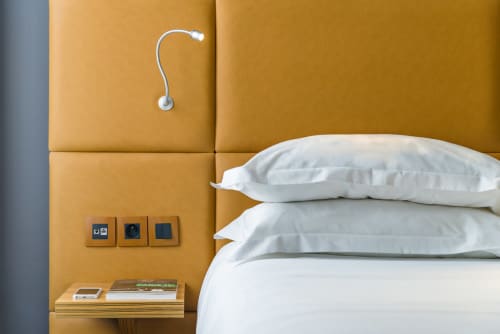 Comfort Room at Hotel Residence Europe & Spa with gold padded headboard, white pillows, bedside shelf, and modern wall