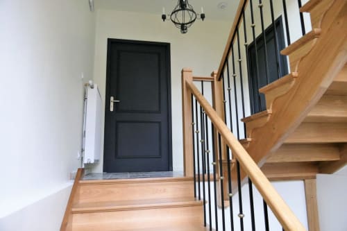 Escalier moderne aux marches en bois et rampe en métal noir à La Maison Virginie, Montargis, porte d'entrée noire