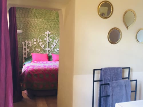 Le Mas Saint Martin villa bedroom in Ollioules with ornate headboard, pink bedding, and decorative mirrors