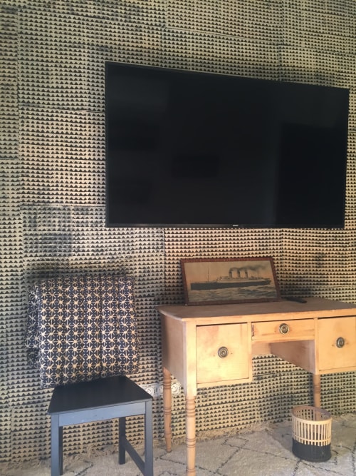 Cozy villa bedroom at Saint Martin B&B in Ollioules with flat-screen TV, wooden desk, and geometric patterned wallpaper
