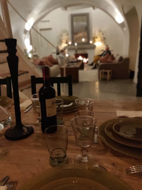 Table élégante à Saint Martin B&B à Ollioules avec bouteille de vin, couverts et arcade vers le salon