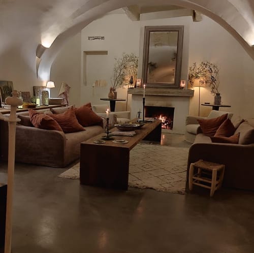 Saint Martin B&B cozy lounge with fireplace, arched ceilings, beige sofas and terracotta pillows in Ollioules