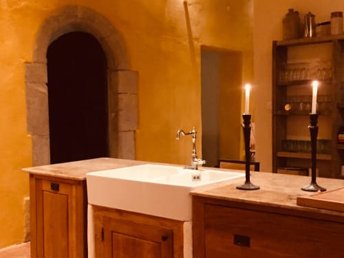 Rustic bathroom at Saint Martin B&B in Ollioules with white farmhouse sink, arched doorway, and candlelit ambiance