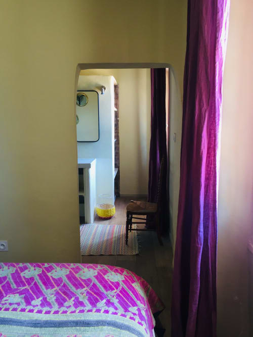 Mirror view of bedroom at Saint Martin BnB in Ollioules, France, showing colorful bedding and doorway