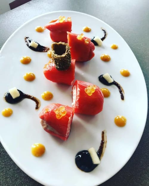 Postre gourmet presentado en Ty Pals Pals con gelatina roja, caviar dorado y adornos artísticos