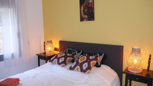 Cozy bedroom at Ty Pals villa in Pals with warm lighting, decorative pillows, and ambient bedside lamps