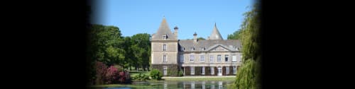 Château d'Alexis de Tocqueville B&B reflected in water, surrounded by lush gardens and trees