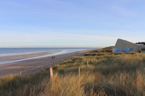Coastal beach view with dunes and blue beach huts near Tocqueville, France