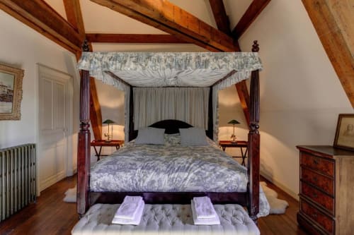 Luxurious canopy bed in wood-beamed suite at Château d'Alexis de Tocqueville, French countryside B&B