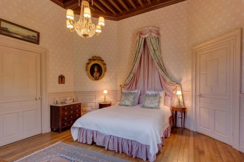 Chambre élégante du Château d'Alexis de Tocqueville avec lit à baldaquin, lustre et décoration française classique