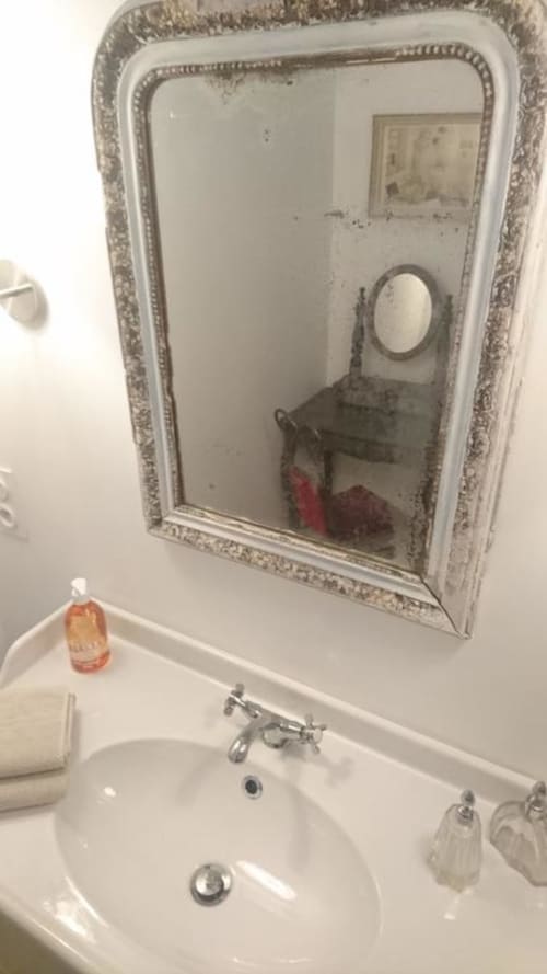 Lavabo de salle de bain avec miroir encadré orné au gîte Mas des Artistes à Mouriès, France