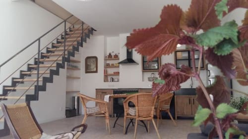 Mazet 1 cottage at Mas des Artistes with open-plan kitchen, dining area, wicker chairs, and staircase in Mouriès.