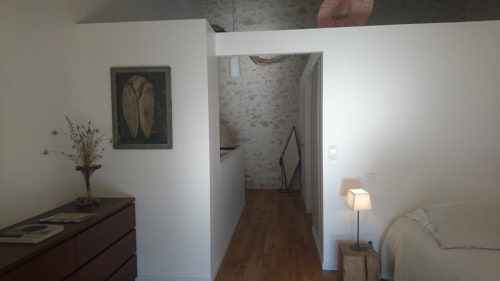 Cozy cottage bedroom with sitting area, white walls, wooden flooring, and garden view at Mas des Artistes B&B in Mouriès