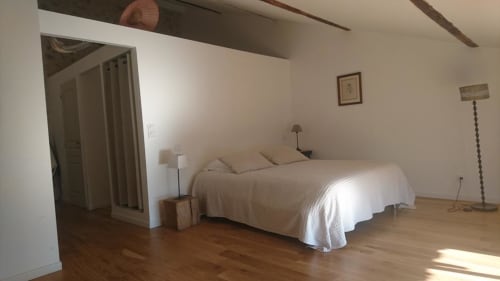 Spacious bedroom in Mazet 1 cottage at Mas des Artistes, Mouriès with bed, wooden floors, and garden view