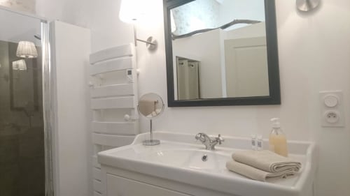 Modern bathroom in Mazet 1 cottage at Mas des Artistes, Mouriès with white sink, framed mirror, and shower area