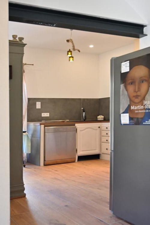 Modern kitchen in The Mas cottage at Mas des Artistes, Mouriès, with white cabinets, stainless steel appliances, and dark